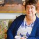 Comedian Kathy Burke sitting comfortably on a sofa, discussing her views on motherhood and gender.