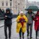 People struggle with umbrellas in heavy rain and wind as Storm Benjamin approaches the UK.