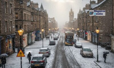 Pedestrians in winter coats walk down a frosty UK city street, with a light dusting of snow or sleet visible on rooftops and in a nearby park, illustrating the weekend cold snap.